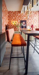 ein Esszimmer mit einem Tisch und einem orangefarbenen Stuhl in der Unterkunft De Oranjestad - In de winkelstraat in Breda + 3 Fotos