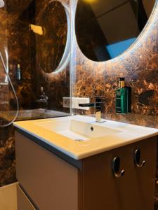 ein Badezimmer mit Waschbecken und Spiegel in der Unterkunft De Oranjestad - In de winkelstraat in Breda