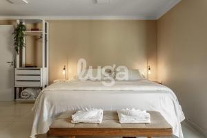 a bedroom with a white bed with two towels at Vieira Eco Inn – Master Suite Vanderleia in Orleans