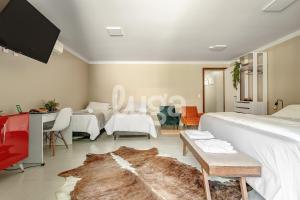 a bedroom with two beds and a tv on the wall at Vieira Eco Inn – Master Suite Vanderleia in Orleans +15 photos