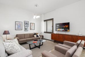 a living room with two couches and a flat screen tv at Casa Centrale by Nomads - 2BD Home with Workspace in Paphos