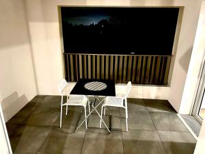 ein Tisch und Stühle in einem Raum mit einem großen Fenster in der Unterkunft Réf A Chambre à 6 min de Disneyland Paris in Chessy + 7 Fotos