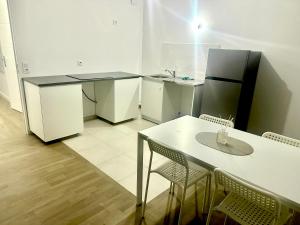 eine kleine Küche mit Tisch und Kühlschrank in der Unterkunft Réf A Chambre à 6 min de Disneyland Paris in Chessy