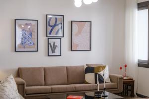 a living room with a couch and nine pictures on the wall at Casa Centrale by Nomads in Paphos City +5 photos