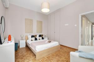 a white bedroom with a bed and a couch at Casa Centrale by Nomads in Paphos City