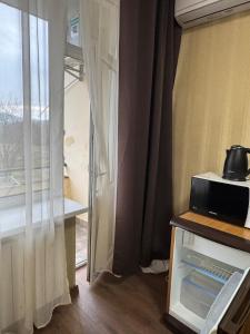 ein Zimmer mit einer Tür zu einem Fenster mit Mikrowelle in der Unterkunft Унікальні двокімнатні апартаменти класу ЛЮКС in Solotschyn