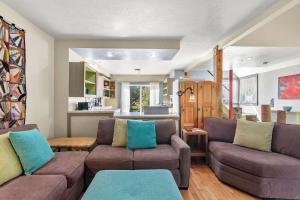 ein Wohnzimmer mit 2 Sofas und einer Küche in der Unterkunft Tranquil Cozy Cottage Recently Renovated in Wellfleet