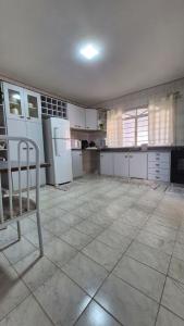 eine große Küche mit weißen Geräten und einem gefliesten Boden in der Unterkunft Casa ampla perto do Aeroporto de Viracopos in Viracopos + 29 Fotos