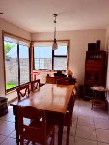 une salle à manger avec une table en bois et des fenêtres dans l'établissement Casa Yemel, à Coyhaique 10 autres photos