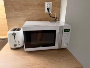 a microwave sitting on the floor next to a toaster at Lumio in Košice