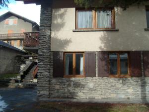 a stone house with wooden doors and windows at Stellina in Lanslevillard