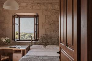 ein Schlafzimmer mit Bett, Schreibtisch und Fenster in der Unterkunft Villa Ampeli in Vasilikos