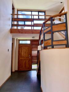 un escalier dans une maison avec une porte en bois dans l'établissement Casa Yemel, à Coyhaique