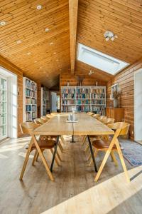 een grote kamer met een grote houten tafel en stoelen bij Timber House On Dune Plot Near Hulsig in Hulsig +20 foto's