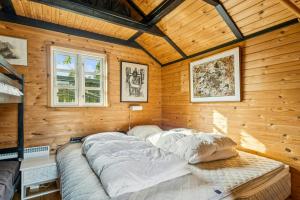 een groot bed in een kamer met houten wanden bij Timber House On Dune Plot Near Hulsig in Hulsig