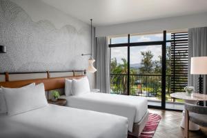 a hotel room with two beds and a large window at Mövenpick Kigali in Kigali