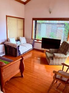 un salon avec un canapé, des chaises et une télévision dans l'établissement Casa Yemel, à Coyhaique