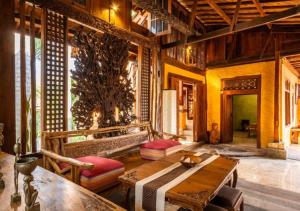 un salon avec une table en bois et un canapé dans l'établissement Villa Honey, à Montongbuwoh