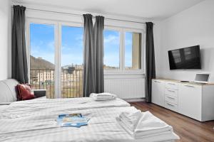 una camera da letto con un letto e una grande finestra di Prague City Residence a Praga