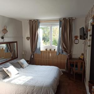a bedroom with a large bed and a window at Havre de paix au bords de l'Eure - divers hébergements in Neuilly