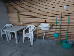 a table and two chairs and a sink on a patio at Kitnet geminada próximo da praia in Torres