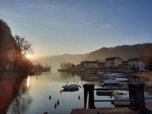 a group of boats are docked in a river at Casina al Lago in Lavena Ponte Tresa