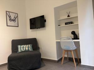 a living room with a chair and a television at Casina al Lago in Lavena Ponte Tresa