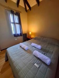 a bedroom with a large bed with two pillows on it at Cabañas Valle Nabú in Lago Puelo +11 photos