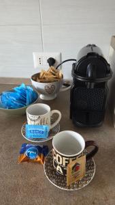 a table with cups of coffee and a toaster at Rocca view central flat in Arona +4 photos