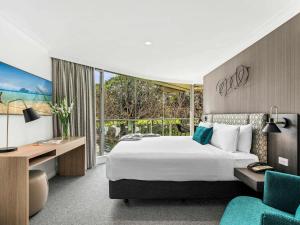 a hotel room with a large bed and a desk at Pullman Quay Grand Sydney Harbour in Sydney +78 photos