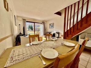 a dining room table with plates on top of it at Appartement cosy 3 pièces pour 6 pers. - Serre Chevalier - FR-1-330F-26 in Serre Chevalier
