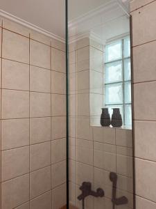 baño con ducha con lavabo y ventana en Achinoeè, en Chalkida