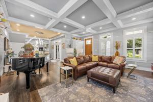 een woonkamer met een bank en een piano bij Heated Pool Outdoor Kitchen Luxury Living in Harwich