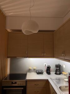 una cocina con armarios de madera y luz eólica en Achinoeè, en Chalkida 11 fotos más