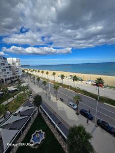 a view of a street and the beach with palm trees at Vista bella luxurious apartment in Martil