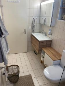 une salle de bain avec un lavabo, des toilettes et un miroir dans l'établissement Centrally located and comfortable apartment - Daubenhorn 32, à Arni Alp