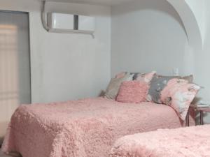 ein Schlafzimmer mit einem rosa Bett mit einer rosa Decke in der Unterkunft la casa de la tia Lucita in Ciudad Juárez