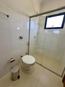 a bathroom with a toilet and a glass shower at Vila dos Pinheiros 2 in Serra Negra +10 photos