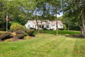une maison blanche avec drapeau dans la cour dans l'établissement Near Corporation Beach Game Room, à East Dennis