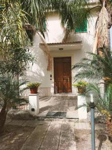 a front door of a house with potted plants at La Villa in Roccella Ionica +2 photos