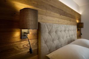 a bedroom with a bed and a lamp on the wall at Die Monika Aparthotel in Gaschurn