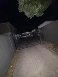 ein Zaun bei Nacht, dahinter ein Auto geparkt in der Unterkunft Exquisite and Classic Apartment in Brisbane