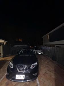 ein schwarzes Auto, das nachts in einer Einfahrt geparkt ist in der Unterkunft Exquisite and Classic Apartment in Brisbane