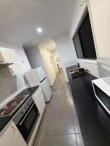 eine Küche mit weißen Geräten und einem großen Fenster in der Unterkunft Exquisite and Classic Apartment in Brisbane