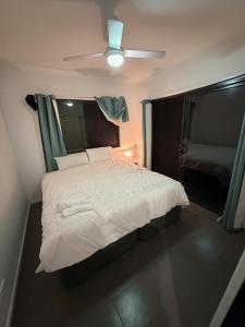 ein Schlafzimmer mit einem weißen Bett mit Deckenventilator in der Unterkunft Exquisite and Classic Apartment in Brisbane