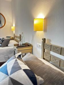 a hotel room with two beds and a lamp at Mas Ribas Hotel i Esdeveniments in Palamós +24 photos