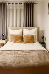 ein Schlafzimmer mit einem großen Bett mit weißen Laken und Kissen in der Unterkunft Wohnung mit Balkon in Wilnsdorf