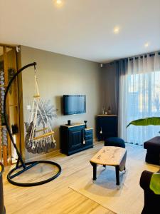 a living room with a tv and a coffee table at Villa Palmiers 5 min de la Mer, confortable 4 Personnes, parking free, in Sérignan