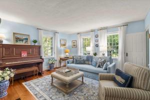 a living room with a couch and a piano at Steps From Downtown Minutes From Grays Beach in Yarmouth