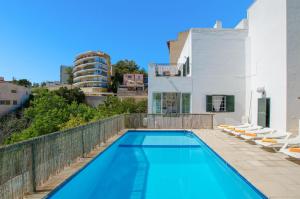 a swimming pool with chairs and a building at YourHouse Ca Na Salera in Palma de Mallorca